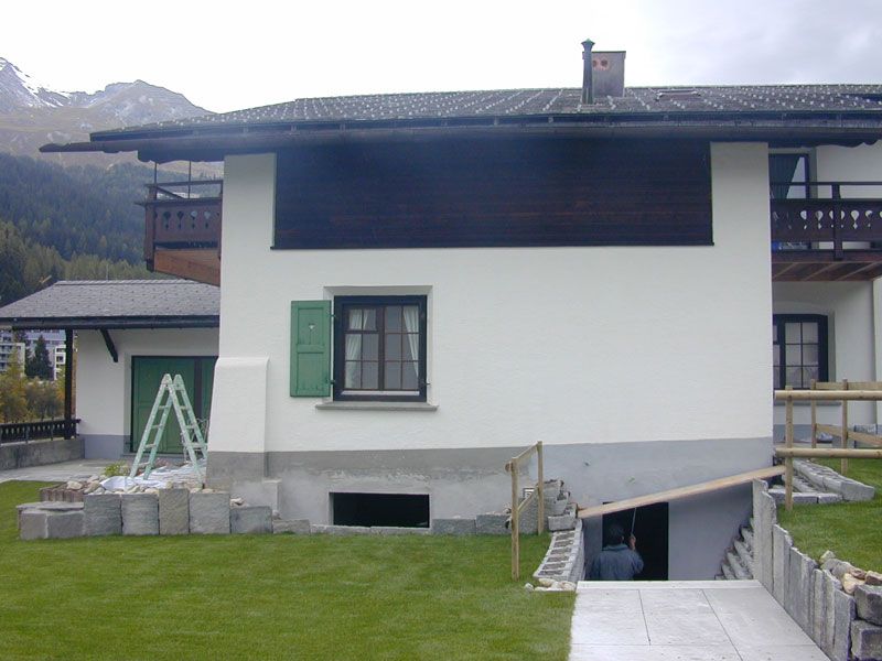 Einfamilienhaus mit weisser Fassade und grünen Fensterläden